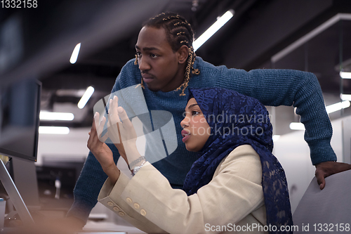 Image of young black muslim female software developer at work