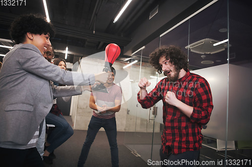 Image of multiethnics business team boxing at office