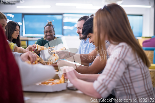 Image of multiethnic business team eating pizza