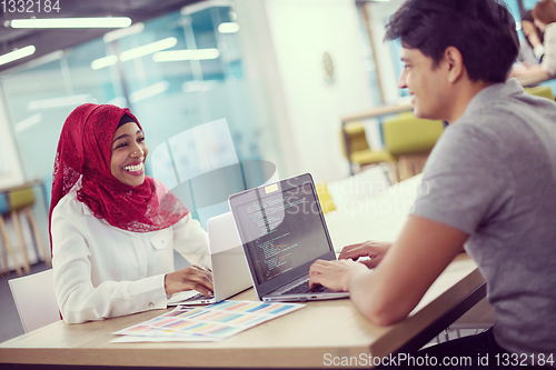 Image of black muslim business woman having a meeting with her indian mal