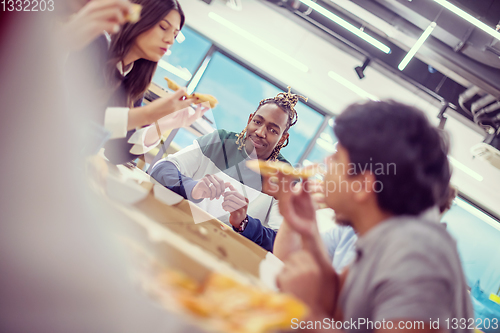 Image of multiethnic business team eating pizza