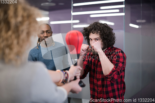 Image of multiethnics business team boxing at office