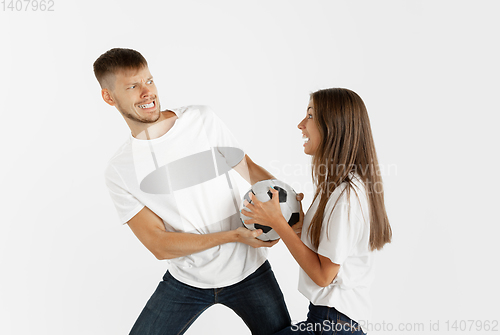 Image of Portrait of beautiful couple football fans on white studio background