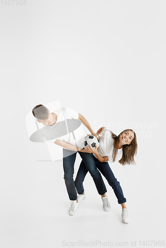 Image of Portrait of beautiful couple football fans on white studio background