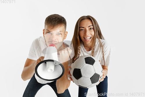 Image of Portrait of beautiful couple football fans on white studio background