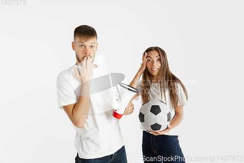 Image of Portrait of beautiful couple football fans on white studio background