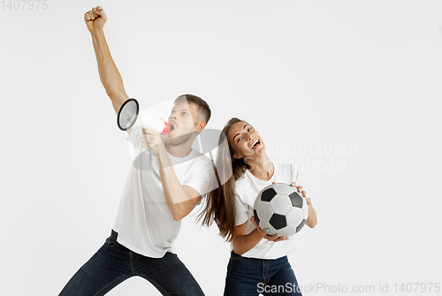 Image of Portrait of beautiful couple football fans on white studio background
