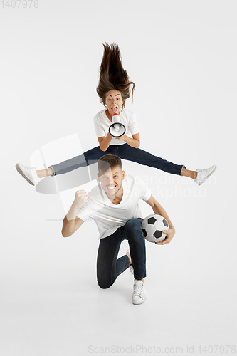 Image of Portrait of beautiful couple football fans on white studio background