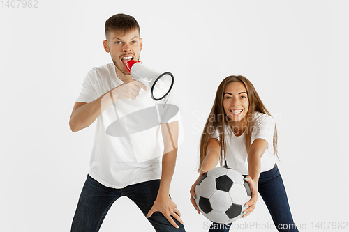 Image of Portrait of beautiful couple football fans on white studio background
