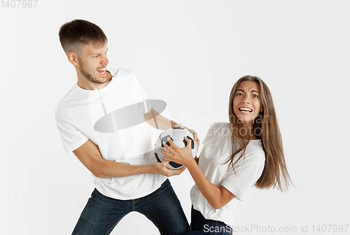 Image of Portrait of beautiful couple football fans on white studio background