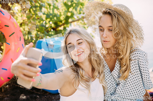 Image of Young lesbian\'s couple having fun and spending time at riverside in sunny day