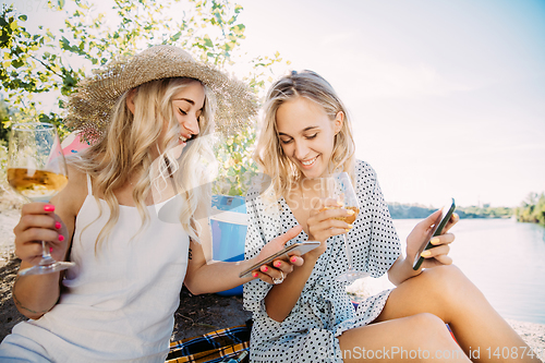 Image of Young lesbian\'s couple having fun and spending time at riverside in sunny day