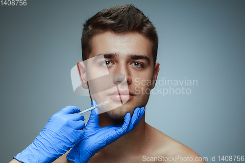 Image of Close-up portrait of young man isolated on grey studio background