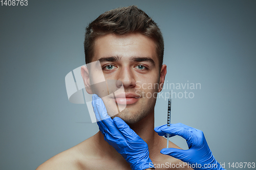 Image of Close-up portrait of young man isolated on grey studio background