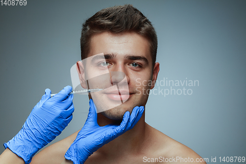 Image of Close-up portrait of young man isolated on grey studio background