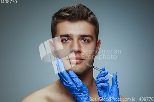 Image of Close-up portrait of young man isolated on grey studio background