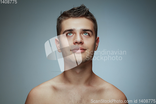 Image of Portrait of shirtless young man isolated on grey studio background