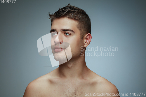 Image of Portrait of shirtless young man isolated on grey studio background