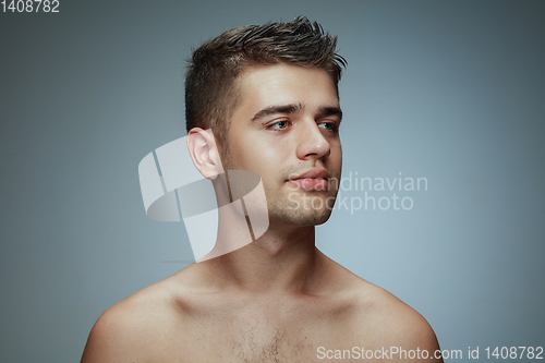Image of Portrait of shirtless young man isolated on grey studio background