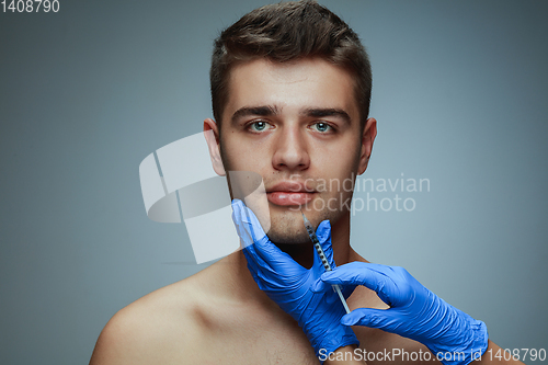 Image of Close-up portrait of young man isolated on grey studio background