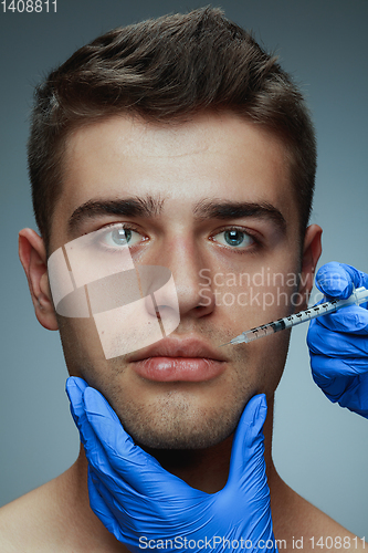 Image of Close-up portrait of young man isolated on grey studio background