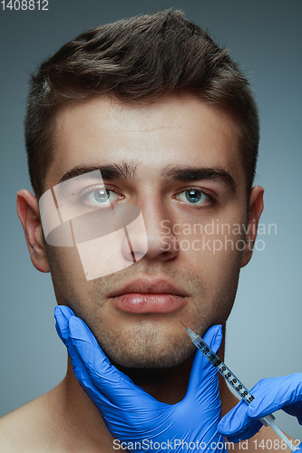 Image of Close-up portrait of young man isolated on grey studio background