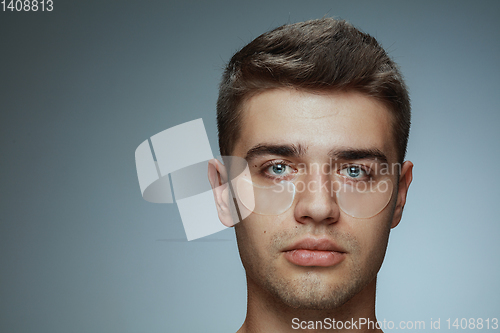 Image of Close-up portrait of young man isolated on grey studio background