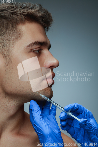 Image of Close-up portrait of young man isolated on grey studio background