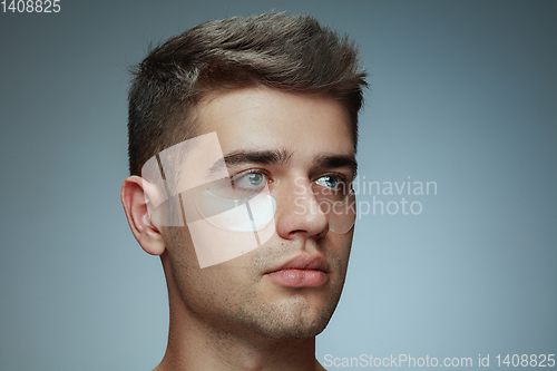 Image of Close-up portrait of young man isolated on grey studio background
