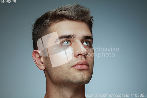 Image of Close-up portrait of young man isolated on grey studio background