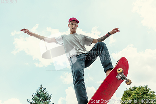 Image of Skateboarder doing a trick at the city\'s street in sunny day