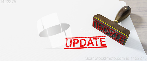 Image of red update stamp on white paper background