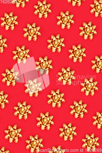 Image of Christmas Gold Ribbon Bow Pattern on Red Background 