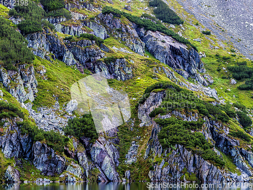 Image of Mountain slope with small lake at botom