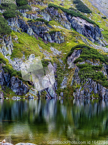 Image of Mountain slope with small lake at botom