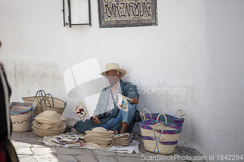 Image of Elder street vendor selling handmade souvenirs 