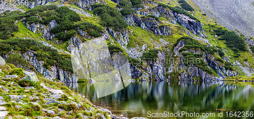 Image of Mountain slope with small lake at botom