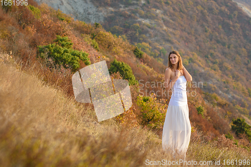 Image of Beautiful slender girl in white clothes on the background of a beautiful mountain landscape