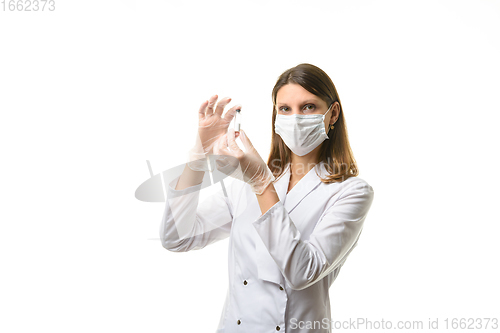 Image of Girl doctor stands with a glass test tube in her hands