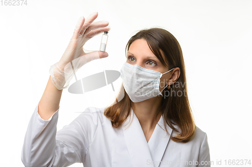 Image of Doctor looks closely at the drug in a test tube, focusing on the doctor