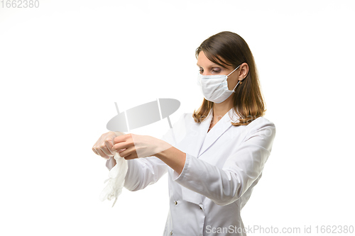 Image of Girl doctor unfolds medical gloves before putting them on