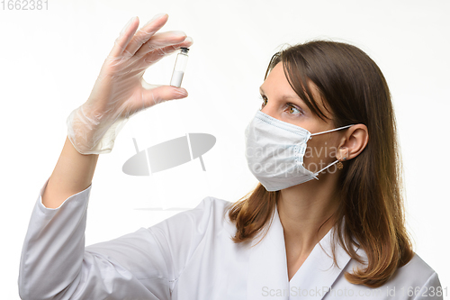 Image of The doctor looks closely at the drug in the test tube,