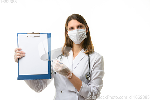 Image of The doctor shows with a pen something in a tablet with a white sheet of paper