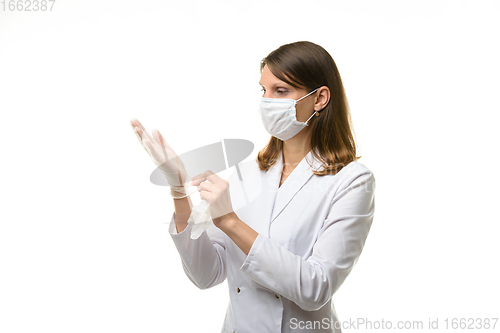 Image of Girl doctor puts on transparent medical gloves on her hands