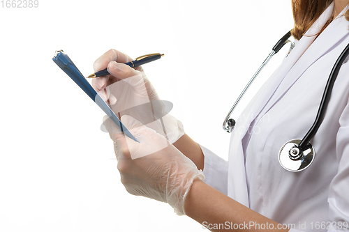 Image of View of the hands of a doctor writing down a patient\'s diagnosis in a tablet