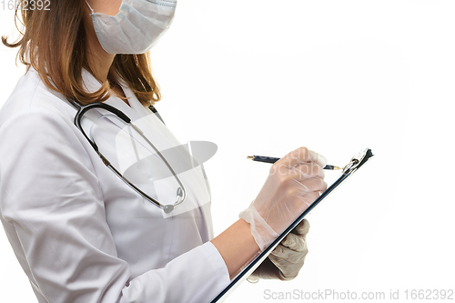 Image of The doctor writes with a pen in a clipboard on a piece of paper