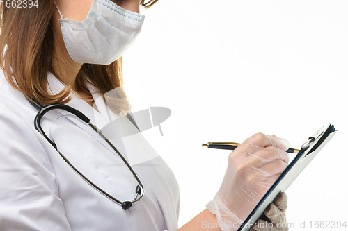 Image of Doctor writes with a pen in a tablet computer on a sheet of paper, close-up