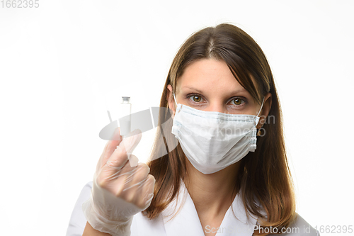 Image of Girl doctor holding a glass tube with white powder in her hands