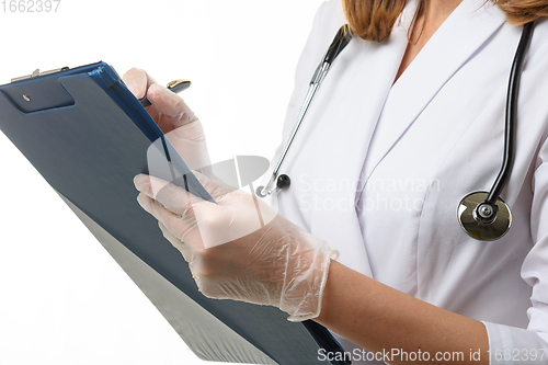 Image of The doctor holds a tablet in his hands and writes down the symptoms of the disease