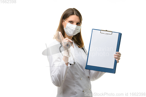 Image of Girl doctor holds a tablet in her hands and shows a warning thumbs up